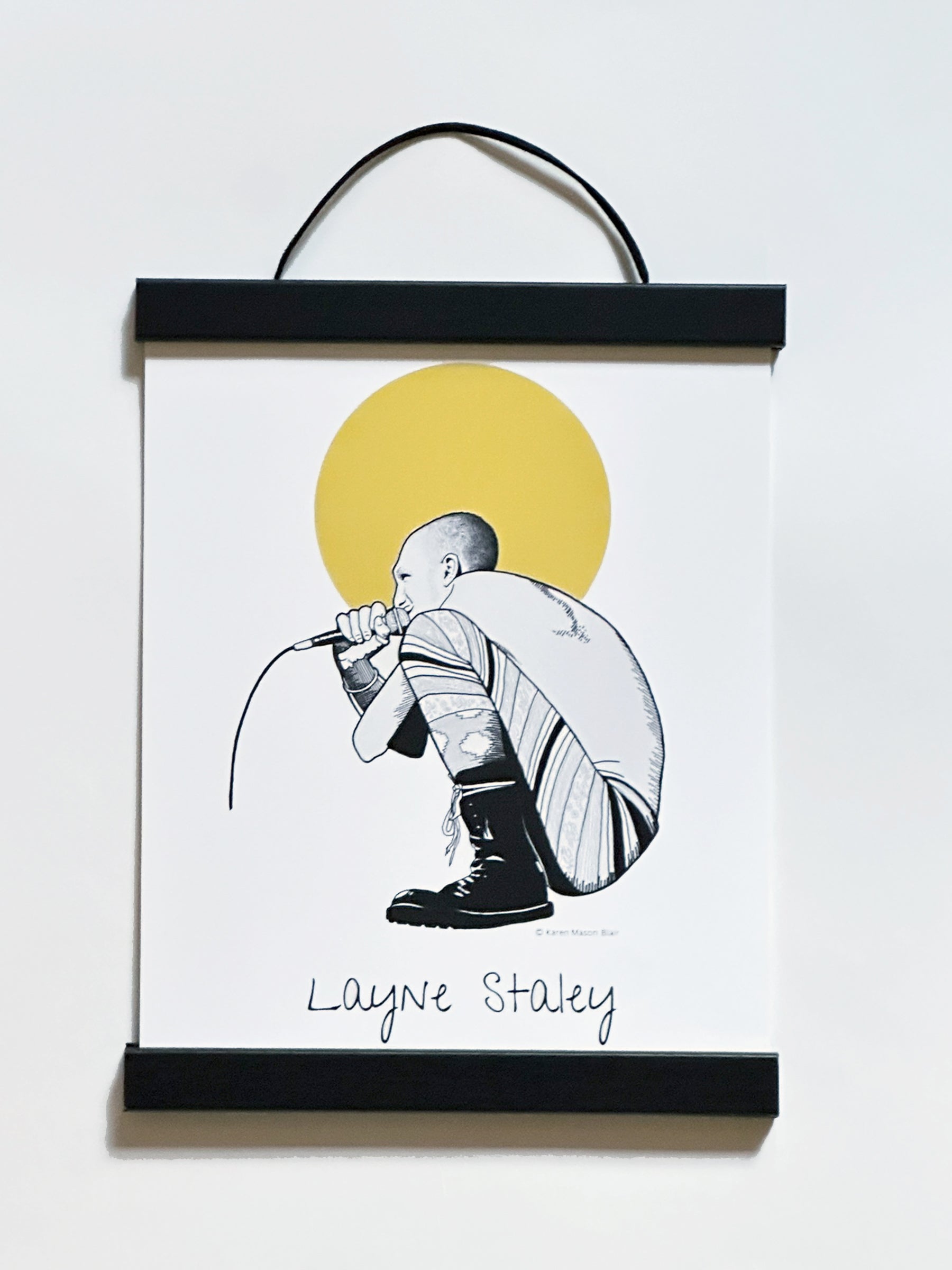 Framed artwork of a Layne Staley Alice in Chains with a microphone against a yellow sun on a white background